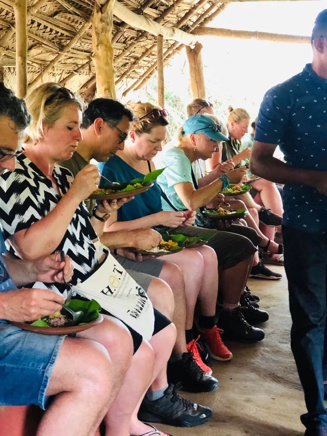 Guests eating a village lunch served on banana-leaf plates